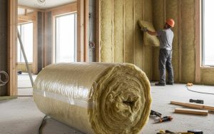 Rouleau de laine de verre sur un chantier d'isolation de murs.