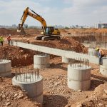 Installation de longrines en béton armé sur un terrain hétérogène pour une fondation stable.